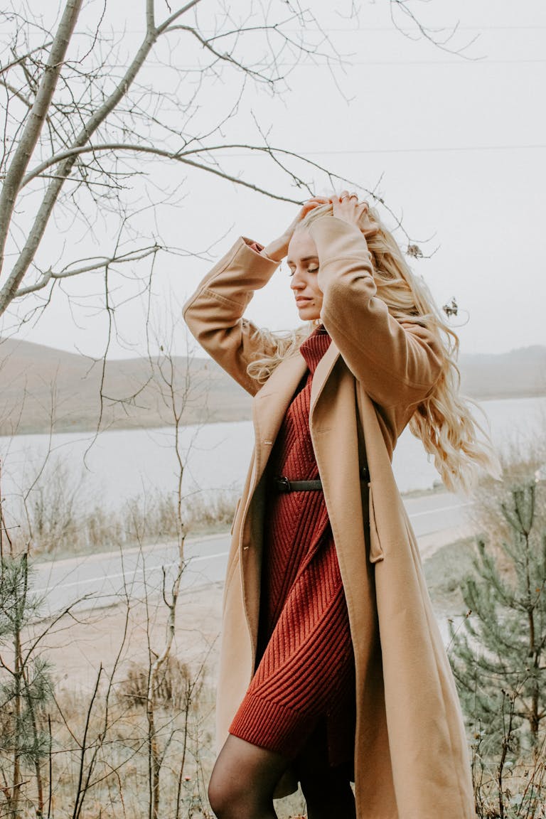 Blonde woman in a fashionable coat and dress outdoors in Minsk, showcasing fall style.