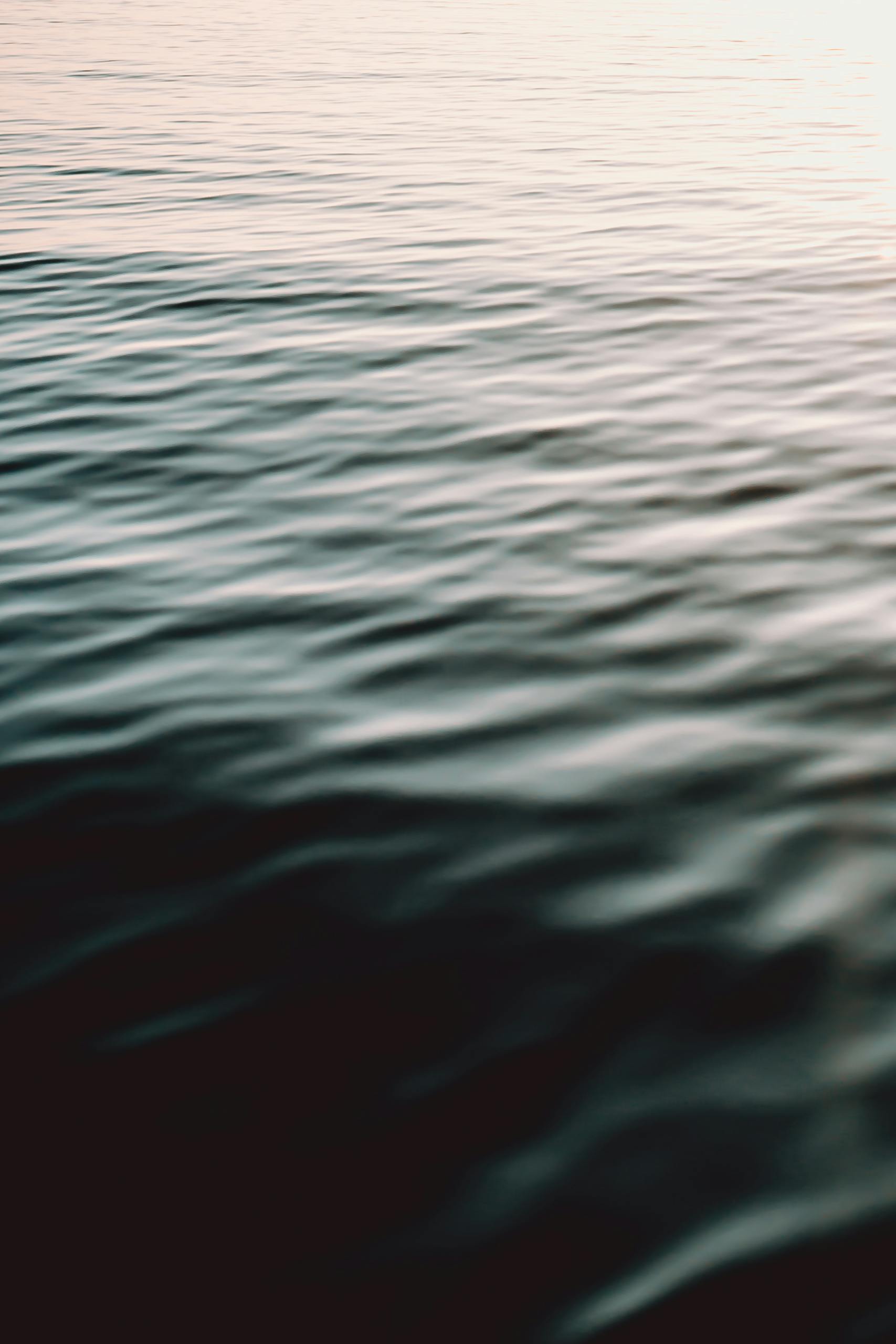 Gentle ripples on the sea captured at sunset, creating a calming and serene atmosphere.