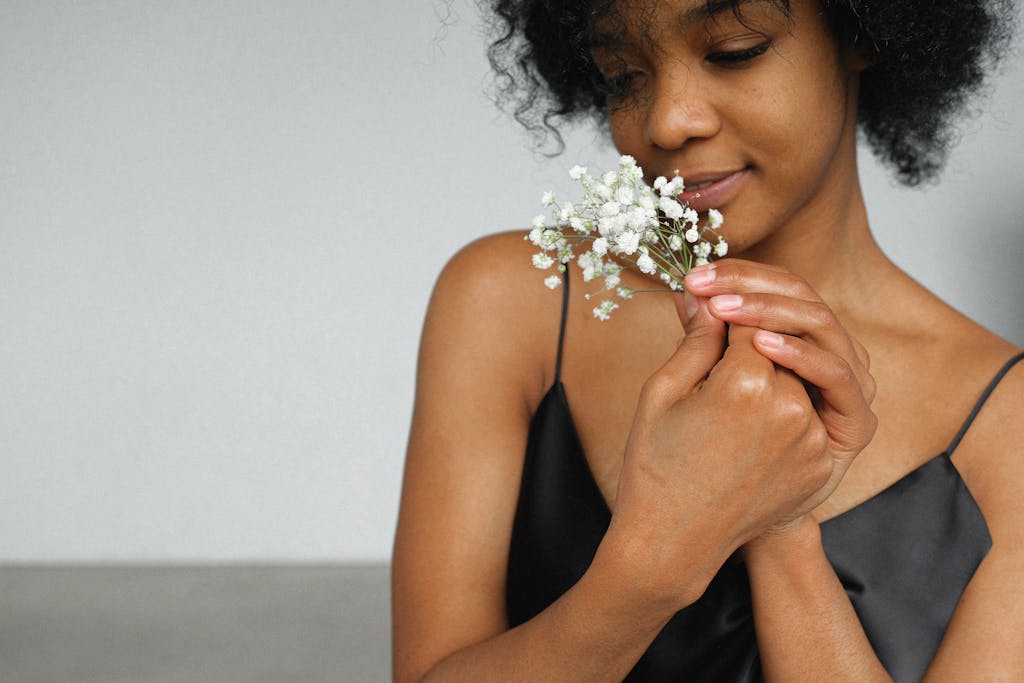 Close-up portrait of a woman gently holding a bunch of baby's breath flowers, emanating elegance.